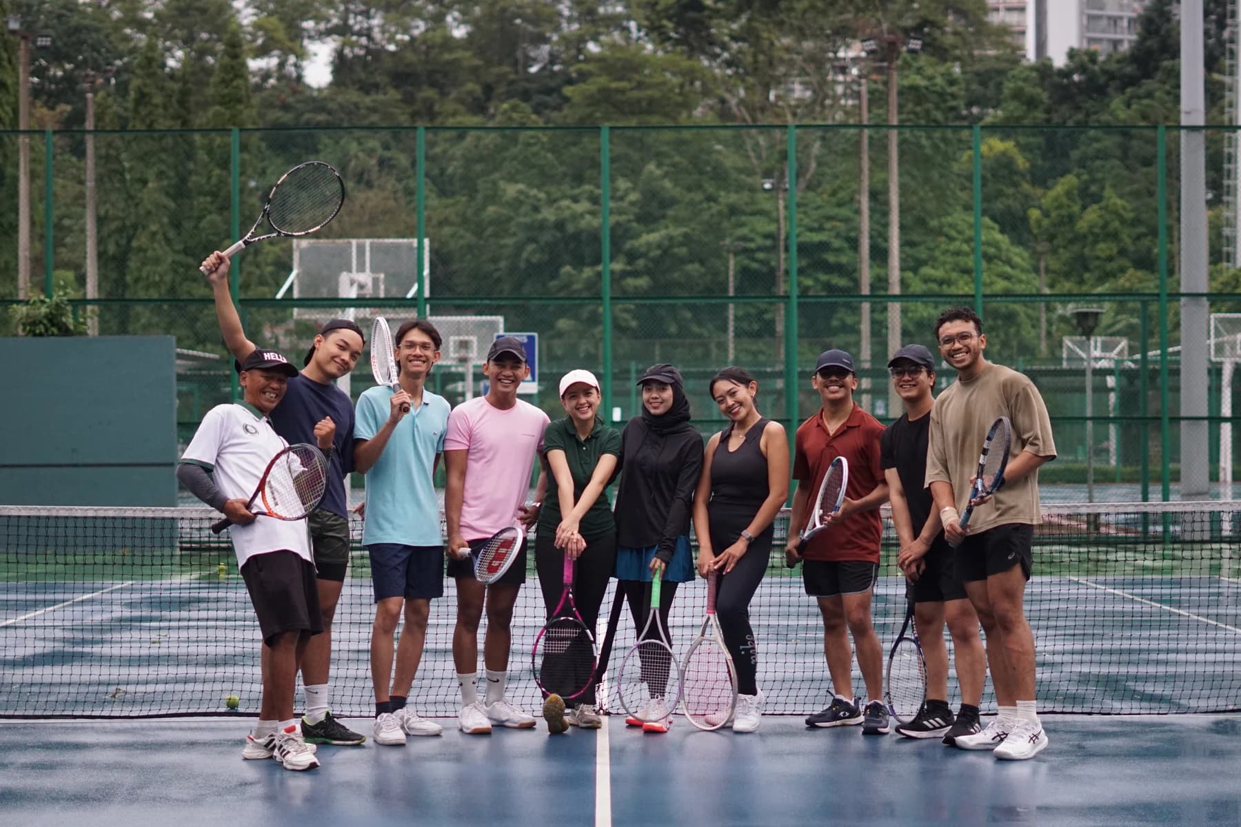 Komunitas Tenis Tenisan bersama di lapangan dengan raket tenis